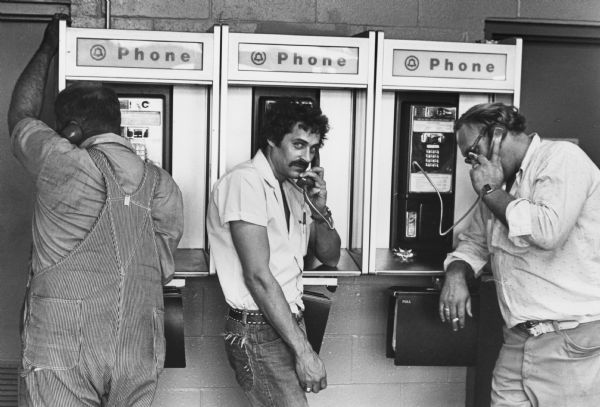 Truck drivers using pay phones at a truck stop off Interstate 90.