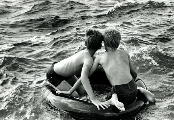 Stuckey Brothers floating on an inner tube on Lake Mendota at James Madison Park.