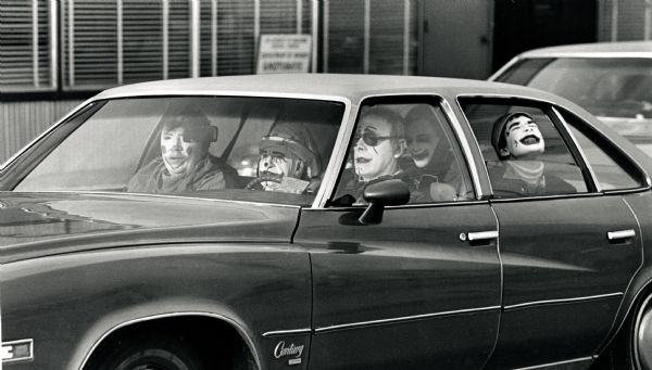 Group of clowns riding in a car after the Thanksgiving Day Parade on Williamson Street.