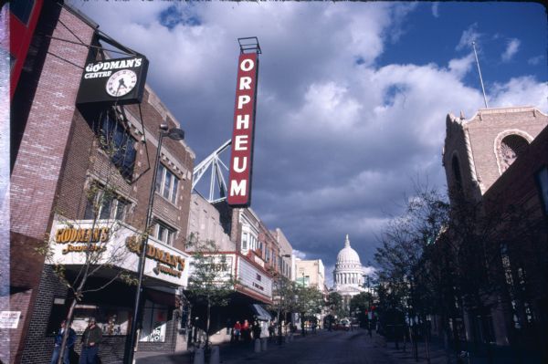 View looking up the 200 block of State Street. On the left are Goodman's Jewelers and the Orpheum Theatre marquee, and on the right is the Capitol Theatre. In the background is the Wisconsin State Capitol.