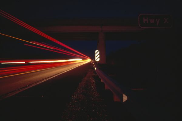 Long exposure at night of cars driving on the interstate near Highway X.