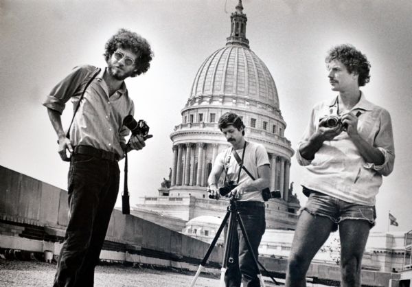 Photojournalists Bob Rashid (center), and Glenn Trudel (right) outside the Wisconsin State Capitol building. The third man on the left is unidentified.