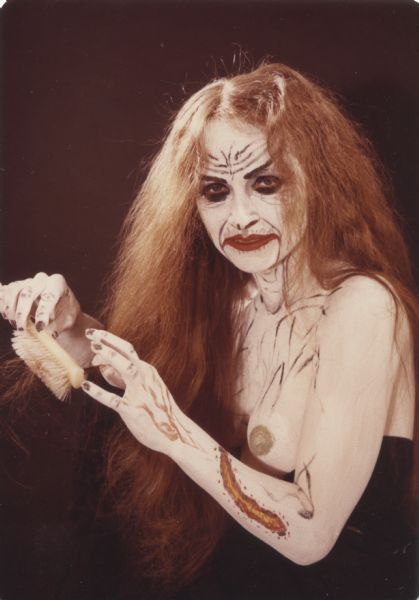 Studio portrait of "Zombie Girl" brushing her hair.