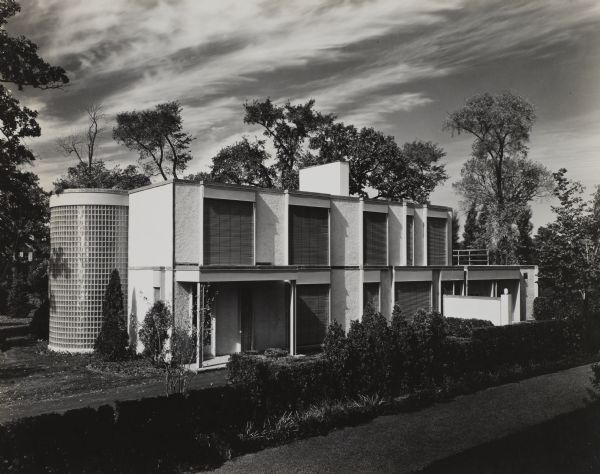 he Herbert Brunig House was designed by the architectural firm Keck and Keck as Project #195 in 1935. Herbert Brunig of the Charles Brunig Co. and his family of five lived in this 15 room home on Blackhawk Road in Indian Hills Estates, Wilmette, Illinois. Keck designed 26 homes in Indian Hills, but it was only the last in the development, the Brunig house, that was designed in the International Style.  The house was framed with welded steel and built with framed/poured concrete and stucco. The finishing was done with wood veneer, rubber floors and plaster. This perspective shows the back of the house.