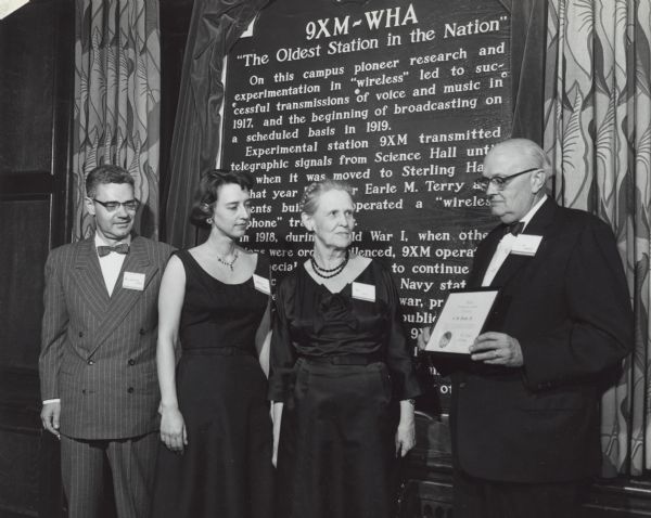 The family of Professor Earle M. Terry and C.M. Jansky, Jr. honor Professor Terry with the C.M. Jansky award at the dedication of the historical marker documenting his successful experiment in wireless broadcasting. Terry's son, Dr. Melvin Terry (left), his daughter, Dr. Dorothy Terry, assistant professor of Psychology at Yale University (middle), and his widow Mrs. Sadie Terry-Gage (right) stand with C.M. Jansky, Jr. (far right) and receive the award. The historical marker was originally located near the Science Hall on the UW Madison campus, where the original experiment took place, but with the relocation of the WHA radio station to the Vilas Communication Hall, the marker moved to the new home of the radio station. 