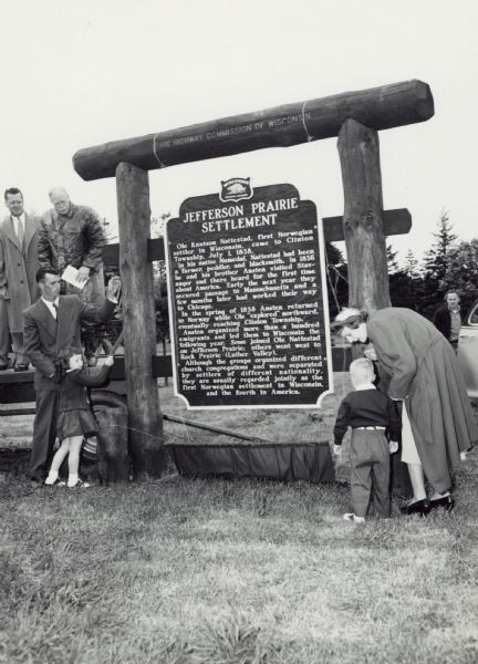Great grandchildren of Ole Knutson Nattestad, the first Norwegian settler in Wisconsin, Sonja Kay and John Carlton, standing with their parents, Mr. and Mrs. Robert Lee, next to the marker honoring their family member at the unveiling ceremony.