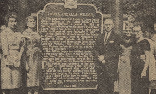 Participants in the dedication ceremony of the Laura Ingalls Wilder historical marker in Pepin, Wilder's birthplace, included, from left to right, Miss Eleanor Sanford, vice-president of the LaCrosse Historical Society, Mrs. William Laux, children's librarian at the LaCrosse public library, Harold Lunde, Pepin school administrator, Miss Reba Wakefield, retired librarian from St. Paul, and Mrs. Jesse Jahnke, Pepin librarian. Miss Wakefield, as a friend of Wilder's, was instrumental in bringing awareness to the importance and impact of Wilder as an author and to the preparation of the historical marker itself. 