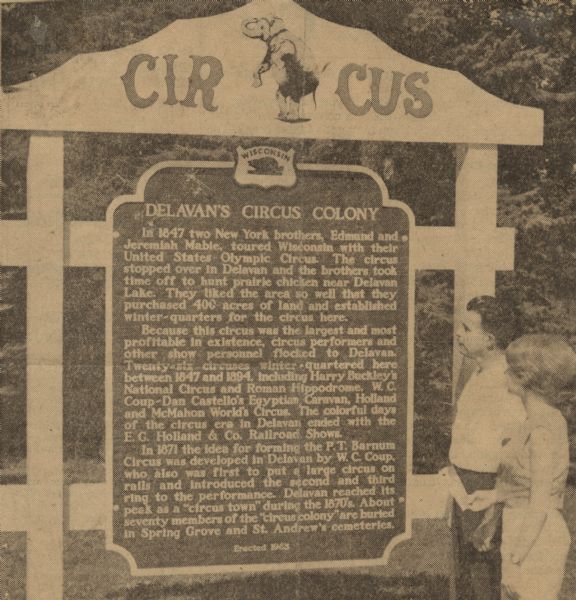 Gordon Yadon, a member of the Mabie Brothers circus tent, and Mary Lou Lawrence, aerialist and trapeze artist, reading the historical marker documenting Delavan's Circus Colony. Mary Lou Lawrence was the Circus Queen of the Delavan Circus Celebration in 1963, during which the historical marker was unveiled to the public, just 5 months after she fell 35 feet mid-act onto the concrete floor.  