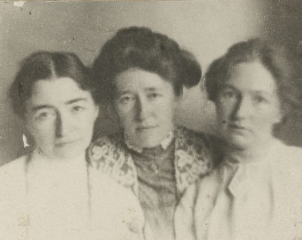 An informal head and shoulders portrait of Helen Farnsworth Mears (1872-1916), left, and her sisters Louise Morilla Mears Fargo (1866-1925), center, and Mary M. Mears (1870-1943). The photograph is mounted on an album page. Helen Mears was a recognized sculptor who had studied with Augustus Saint Gaudens; her sister Mary was the author of four published novels and several short stories. At the time of this photograph, Helen and Mary were living together in New York City. Louise was the wife of Lake Mills businessman Frank B. Fargo.