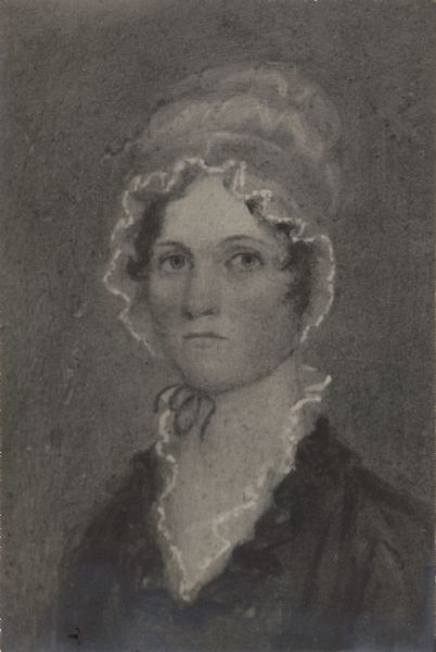 A photographic copy of a head and shoulders oil painting of Polly Harrison.  She is wearing a bonnet with lace trim and a ribbon tied under her chin.  Her dress also has lace trim at the collar.  A caption accompanying the photograph identifies her as the wife of Thomas Mears and notes that she died at age 70 at Fort Covington, New York.  She was the grandmother of Louise Mears Fargo of Lake Mills.