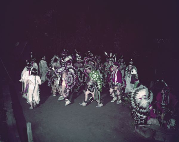 A group of men and women, dressed in ceremonial clothing, performing the Snake Dance at the Stand Rock Indian Ceremonial.