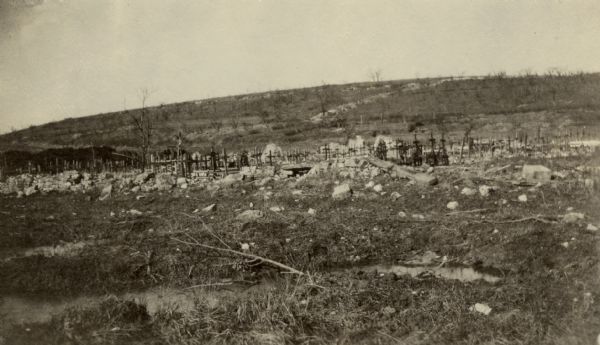 Hundreds of graves for fallen soldiers at Dead Man's Hill. Captioned: "Cemetery at foot of Mort Homme (Dead Man's Hill). Notice the 'communication trenches' leading up the hill."