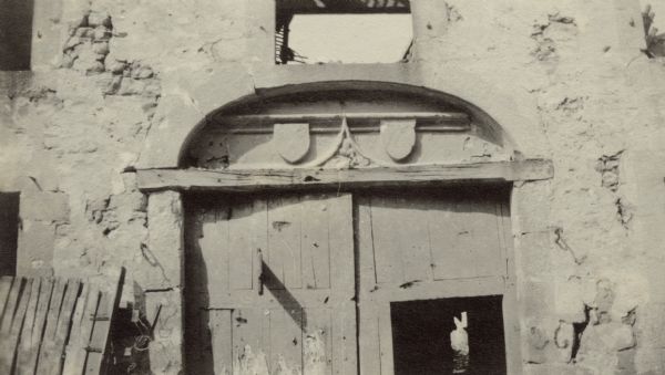 The coat-of-arms of Joan of Arc atop a doorway in Cormicy. Captioned: "Jeanne d'arc, on her way to Reims to coronate Charles VII, stopped at Cormicy overnight and stayed in this house. Until the Germans neared the city, her coat-of-arms adorned the doorway."