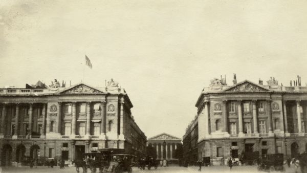View across plaza towards two buildings in the center of Paris. Captioned: "Place de la Concorde. To the left A.P.C. headquarters; to the right, French ministry of marine; straight ahead, the rue Royale with the Madeleine in the background." 
