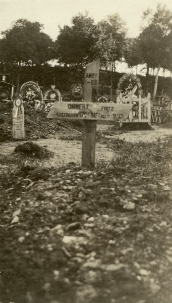 A cross marking the grave of a German soldier. Other graves are in the background. Captioned: "A 'Fritz'."