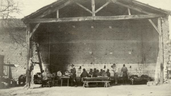 Soldiers gathering in the open air dining room for a meal. Captioned: "Our 'Salle a manger' at Recy."