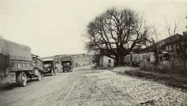View down road towards trucks and ambulances. Captioned: "Part of our cantonment at Dombasle on the road to Verdun."