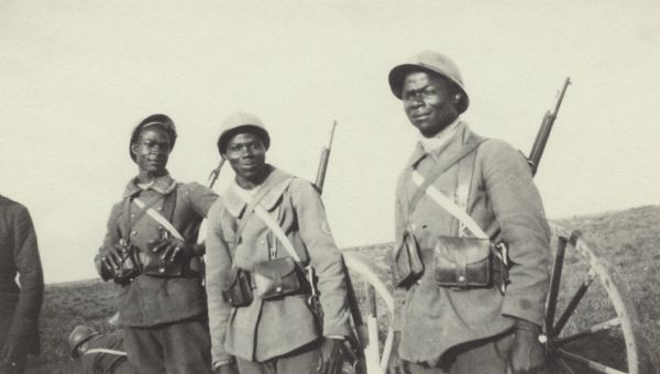Three soldiers posing for a group portrait. Caption reads: "Three handsome African lads, serving in a division from Morocco."