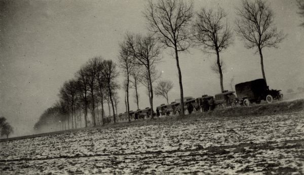 View across field of cars in a convoy. Caption reads: "A stop to wait for broken down cars while in convoy from Paris to Longeville."