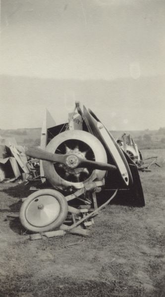 An airplane almost completely broken apart lying on the ground. Caption reads: "A broken Sopwith, an English fighting plane used extensively by the French."
