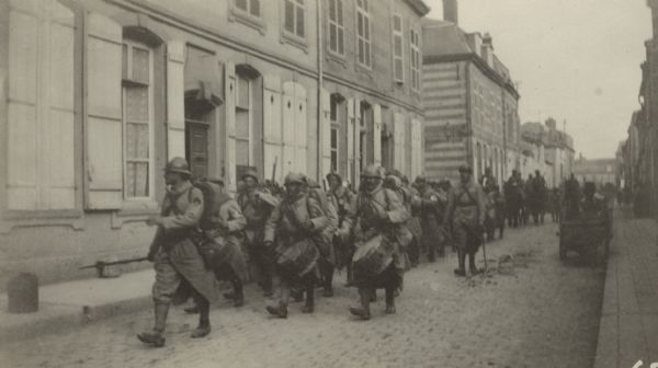 An Army band marching along a street. Caption reads: "Band on our Division (71) marching 'out'-hence the joy. The first band I had seen in France."