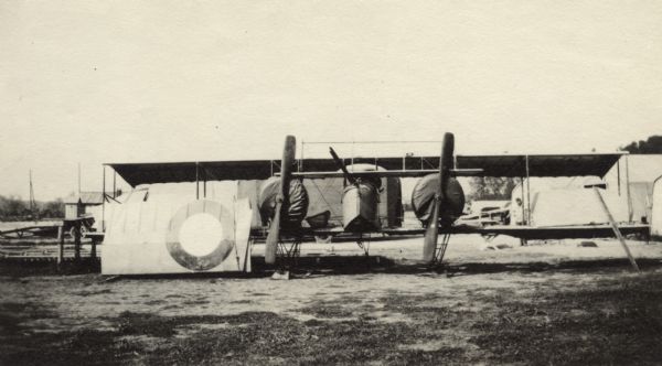 Airplane resting on its landing gear. Caption reads: "A bi-motor caudrone. Valuable for observation, takes the air quickly and is particularly speedy at high altitudes."