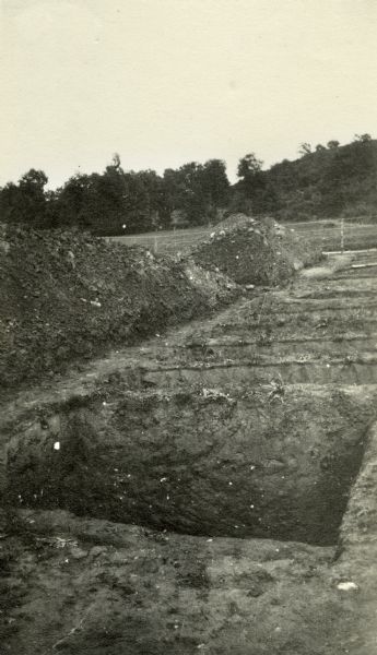 Freshly dug graves and piles of dirt at Vaux Varannes. Caption reads: "Graves for prospective 'guests' at Vaux Varennes."