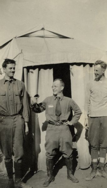 A group of three soldiers are standing in front of a tent and posing for a portrait. Caption reads: "Vaux Varennes. Shorty More, our artist, Shorty Samuels, our pessimist and Slim Borling, our optimist."