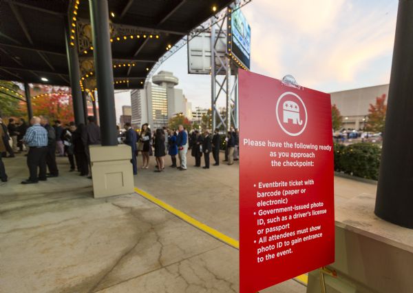 A red sign, bearing the Republican elephant, displays the items all entrants to the Republican presidential debate must show at the checkpoint before being allowed into the Milwaukee Theater. In the background is a line of people waiting to be let into the theater.