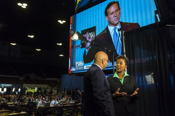 Journalist and reporter, Ali Velshi, interviewing Wisconsin State Senator (4th district) Lena Taylor in the Panther Arena during the Republican presidential debate. Rick Santorum is on the large screen in the background.