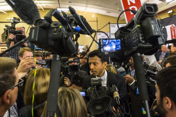 Louisiana Governor Piyush "Bobby" Jindal talking to the media at the Republican presidential debate. Microphones and cameras surround him.