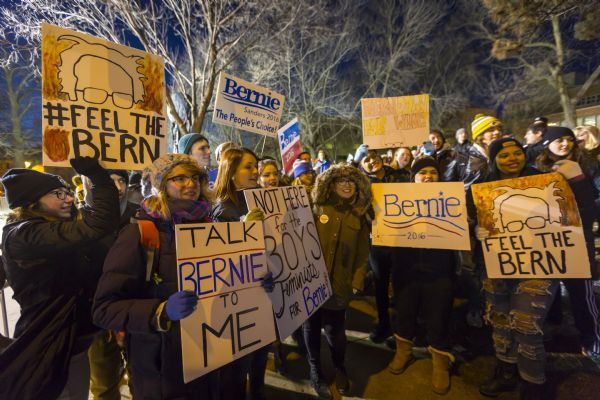 Supporters of Bernie Sanders standing outside the Democratic presidential debate posing with their signs.