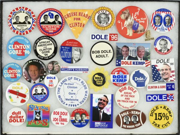 Framed assortment of political campaign buttons for Bill Clinton and running mate Al Gore, and Bob Dole and Jack Kemp. One button favors Clinton's cat Socks, while another calls for Dole's dog Leader as the "first dog." 