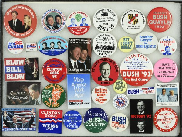 Framed assortment of campaign buttons for Bill Clinton and running mate Al Gore, and George H.W. Bush and running mate Dan Quayle. One button features Clinton playing his saxophone, while another states: "Re-elect Barbara Millie and George too." Several of the buttons speak to specific groups, with independent truckers and country music fans supporting Bush, and teamsters and the graphic communications international union supporting Clinton. Two of the more interesting buttons include one which reads: "But I Didn't Inhale!," a reference to Clinton's discussion of the one time he claimed he experimented with marijuana, and another which reads: "I Have, Have Not, Had An Affair With Bill Clinton," referencing allegations of his affair with Gennifer Flowers.