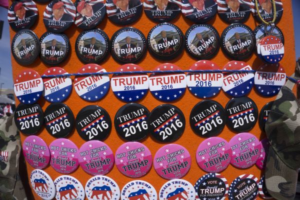 Display of Trump campaign buttons for sale at the Donald Trump rally. Most of the buttons read: "Trump 2016" and include his image or a simple American flag motif background. One set of buttons features the Republican elephant. Another set is bright pink and reads: "Hot Chicks for Donald Trump."