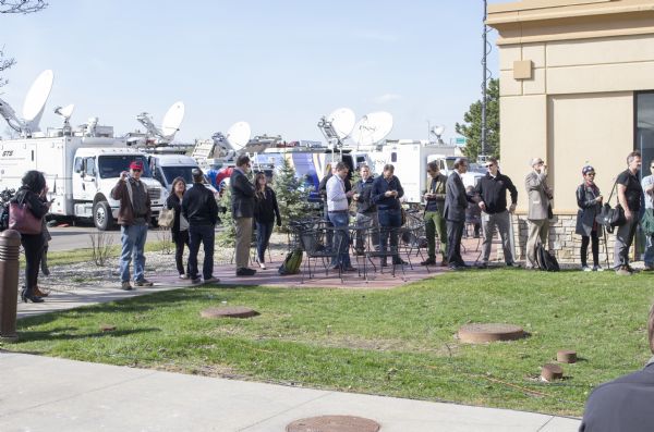 A line of photographers, reporters, and other media personnel lining up in the back of the Janesville Conference Center waiting to enter the Donald Trump rally. Parked behind them are several media trucks. Second in from the left is Andy Kraushaar holding up his Wisconsin Historical Society badge. 