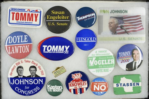 Framed assortment of Wisconsin political campaign buttons ranging from Warren P. Knowles bid for Wisconsin Governor in 1964 to Tommy Thompson's run for president in 2000. 