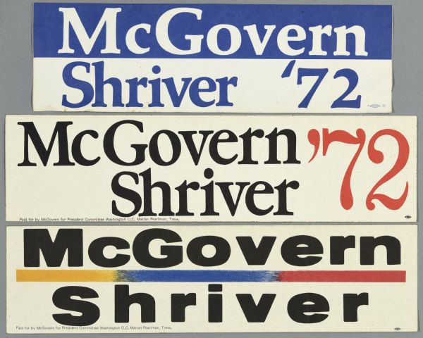 Three bumper stickers for George McGovern and running mate Robert Shriver. The top bumper sticker is blue and white, and the middle bumper sticker is white with black and red text. They read: "McGovern Shriver '72." The bottom bumper sticker reads: "McGovern Shriver," with a yellow, blue, and red horizontal line between the candidates names.