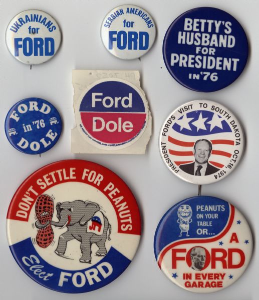 An assortment of seven presidential political campaign buttons, and one sticker, for Gerald Ford and Bob Dole. One of the buttons is blue with white text and reads: "Betty's Husband for President In '76." Two other buttons are about peanuts, referring to the opposing candidate, Jimmy Carter, who was a peanut farmer. One reads: "Peanuts on the table or... A Ford in every garage." The other has an image of an elephant squeezing a peanut with its trunk which reads: "Don't settle for peanuts, Elect Ford."