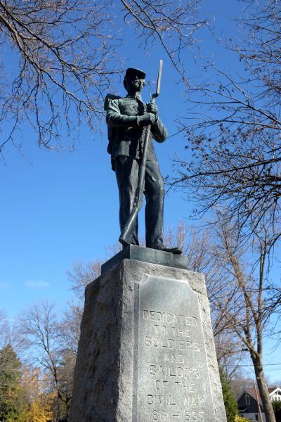 Stone monument topped with a statue of a civil war soldier holding his rifle. The monument reads: "Dedicated to the soldiers and sailors of the Civil War 1861-1865."