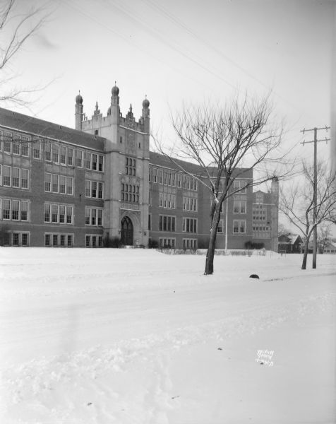 View across snow covered street towards East High School, at 2222 E. Washington Avenue, taken from East Washington Avenue in the winter.
