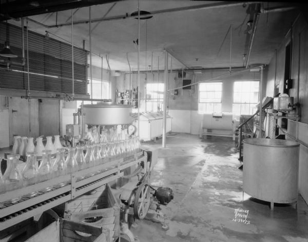 Bowman Dairy, on Fish Hatchery Road. View of the pasteurizing room showing three vats, a churn, and a bottle filling machine.