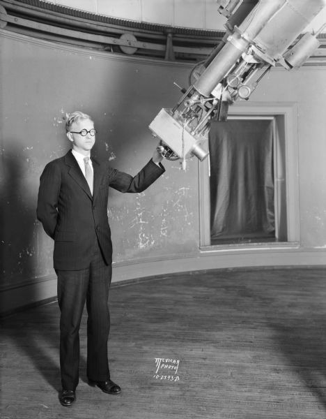 Prof. C. Morse Huffer is standing with the 20 foot telescope in the Washburn Observatory on the University of Wisconsin-Madison campus.
