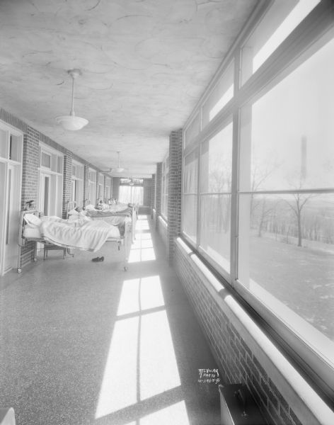 View down sunporch towards patients lying in beds at the Lake View Tuberculosis Sanatorium at 1202 Northport Drive.