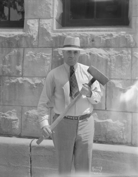 Sheriff Finn holding sledgehammer used to break open the safe of Odin Tofsrud, carpenter and truck farmer, who was murdered during the theft of his safe by several men who drove off with it.