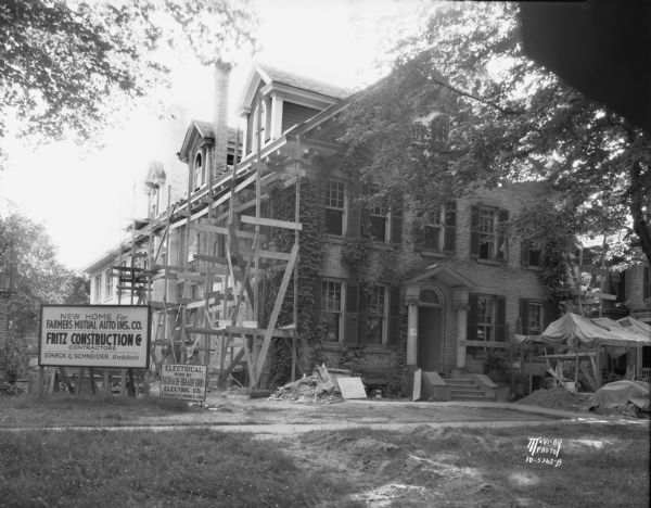 New Farmer's Mutual (now American Family) building at 312 Wisconsin Avenue under construction. Signboards in front read, in part: "New Home for Farmers Mutual Auto Ins. Co., Fritz Construction Co. Contractors, Starck & Schneider Architects."