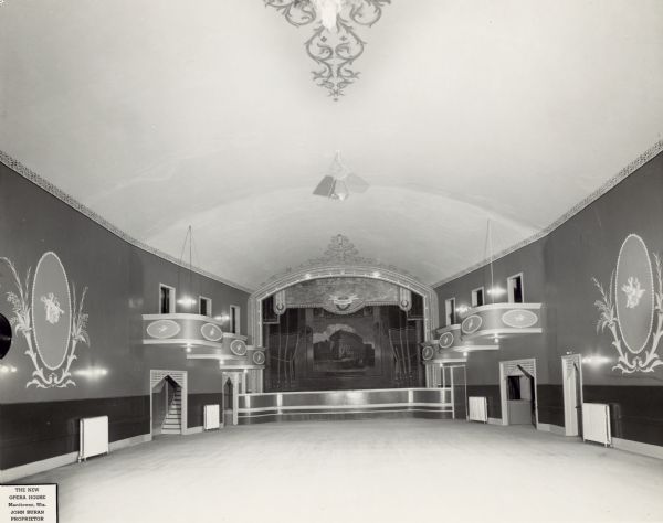 View of the main ballroom of the New Opera House following remodeling. Wreathed cupids and decorative scrollwork embellish the tiered boxes, ceiling and walls. Behind the arched proscenium, is a depiction of the National Theatre in Prague, the Narodni Divadlo, on the stage backdrop. John Buran, an immigrant from Prague, was the proprietor, ca. 1940's. The Ceska Slovanska Lipa Opera House at 411 N. 8th Street was completed by 1889. It was the cultural center of immigrants from Bohemia and Slovakia, now known as the Czech Republic. The building, with a lower-level saloon, was used by its members and the public for events such as holiday programs, Sokol gymnastics exhibitions, school graduations, masquerade and military balls, traveling company shows, band concerts, music clubs, dance classes, car shows, poultry exhibits, wrestling, legitimate theater and silent movies.  In its later years, it was the site of a coffee house and a venue for rock bands. The building was razed in 1975.