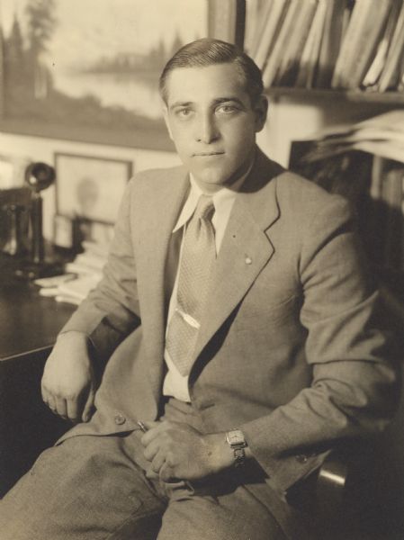 Portrait of Harvey Jacob Stangel (1903-2004), secretary-treasurer of the J.J. Stangel Hardware Company, seated at his desk. His father, Jacob J. Stangel, established the business in 1917 in a new three-story brick structure on the southeast corner of S. 8th and Quay Streets. After Jacob's death in 1922, his sons, Arthur and Harvey, took over management of the company. It was a retail and wholesale hardware business with branch automotive stores in Sturgeon Bay and Sheboygan. Its wholesale territory covered northeastern Wisconsin. As an active community leader, Harvey was involved in the Manitowoc Boy Scout Council and several civic and conservation organizations. He established a tree farm on eighty acres of land east of St. Nazianz.  His farm provided many young people in F.F.A., Scouting and other educational groups the opportunity to plant trees and train in conservation by studying soils, forestry and wildlife management. Honored for his contributions by the local group Conservation Education, Inc. in 1962, the <i>Manitowoc Herald Times</i> stated "Stangel was cited as an outstanding example of a man whose love for people and for nature has made him an ardent supporter and worker in the field of conservation, giving freely of time, thoughts, energies, spare time and financially."
