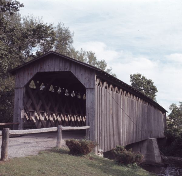 A wooden covered bridge spanning a creek.