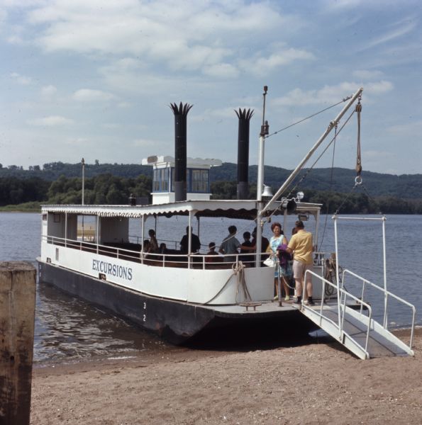 Tourists boarding a paddle steamer along the Mississippi River.